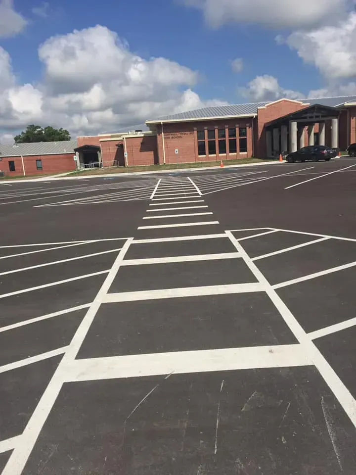 A parking lot with a brick building in the background