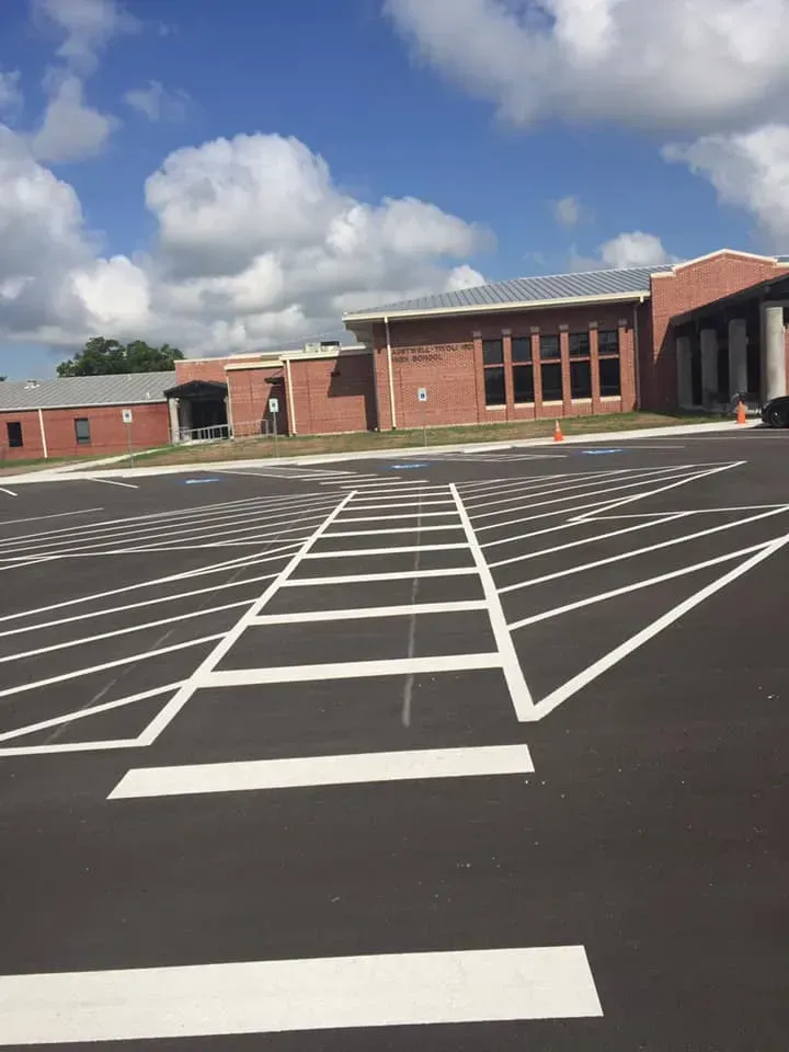 A parking lot with a brick building in the background