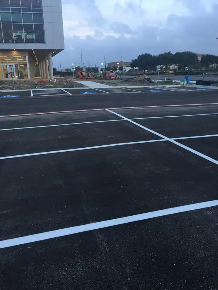 A parking lot with white lines and a building in the background