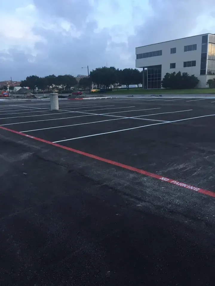 A parking lot with a white building in the background