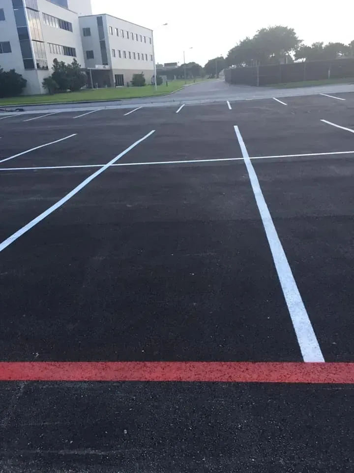 A parking lot with white lines and a red line