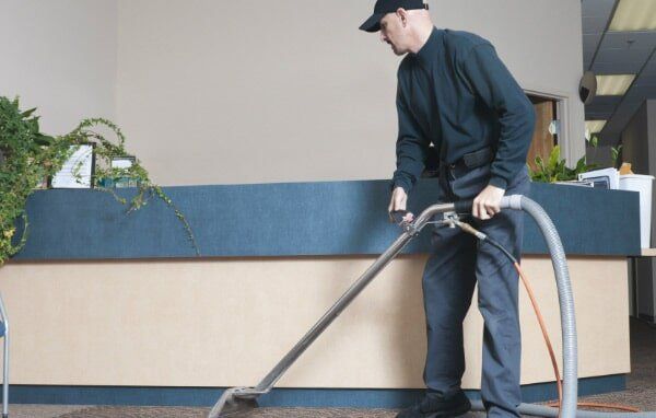 Man Using A Vacuum Cleaner —