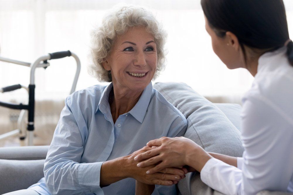 Caring Young Nurse Doctor Carer Helping Holding Hands Of Happy Disabled Handicapped With A Woman Old — Occupational Therapist in Kilgra, NSW