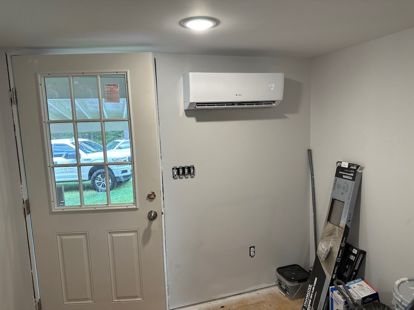 A room with a door and a wall mounted air conditioner.