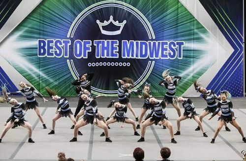 A group of cheerleaders are performing in front of a sign that says best of the midwest