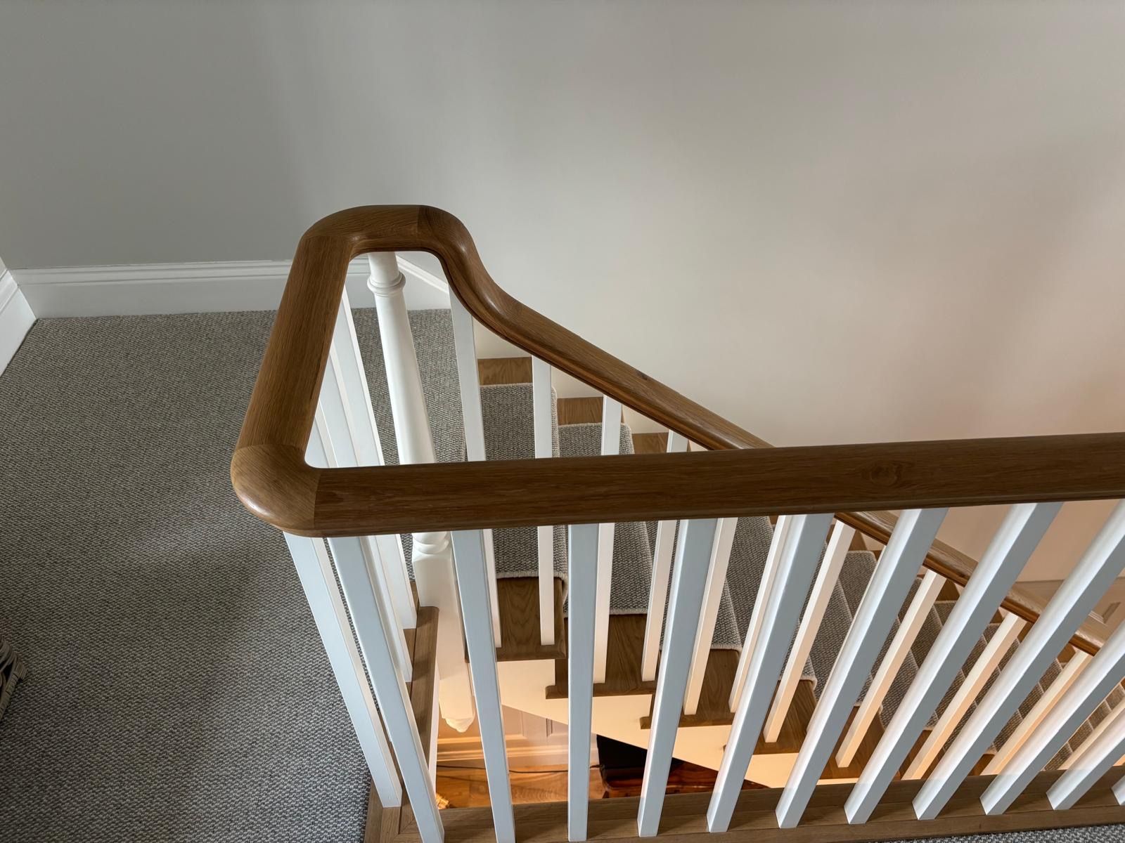 A staircase with a wooden railing and white railings in a house.