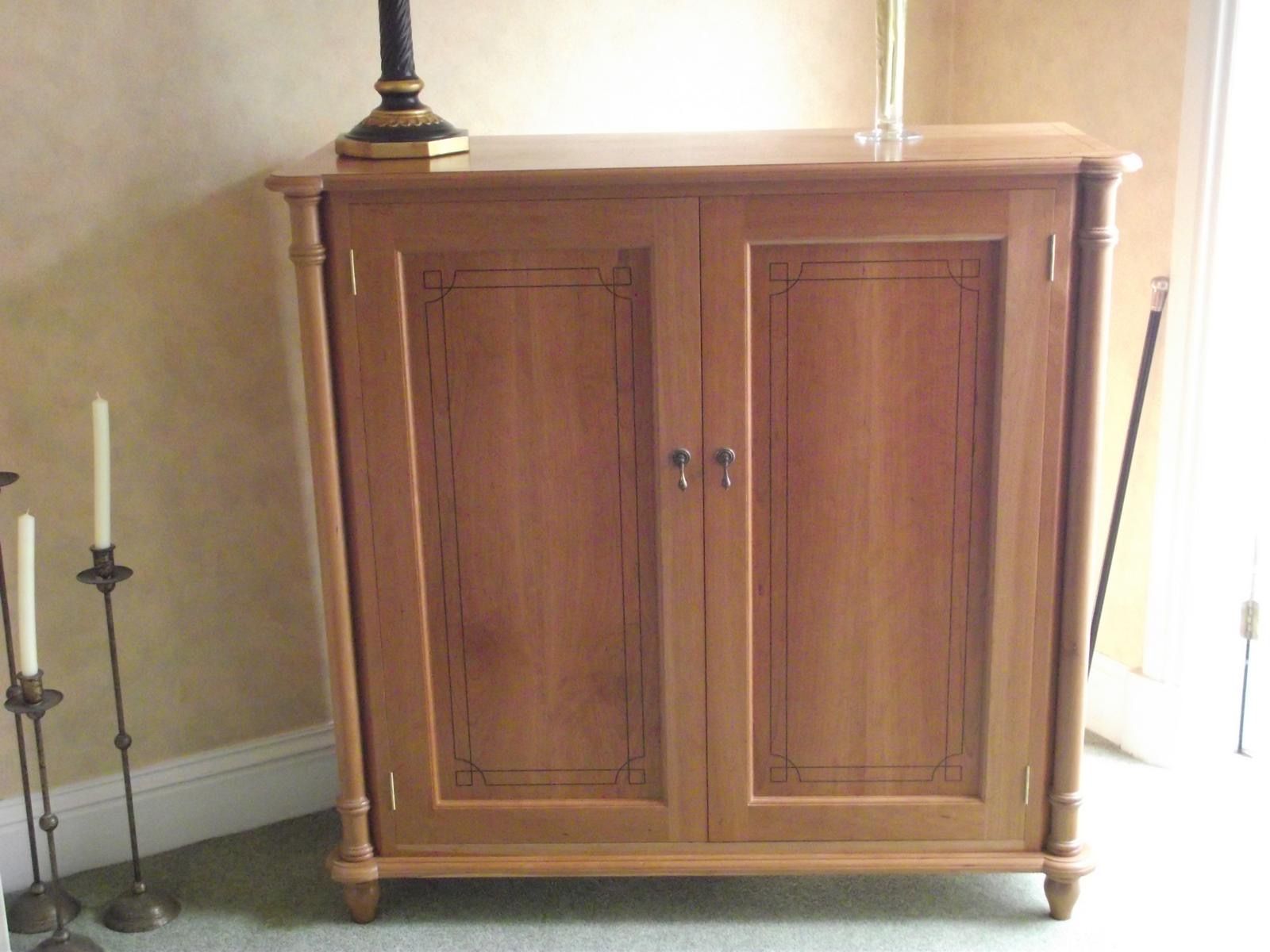 A wooden cabinet with a lamp on top of it