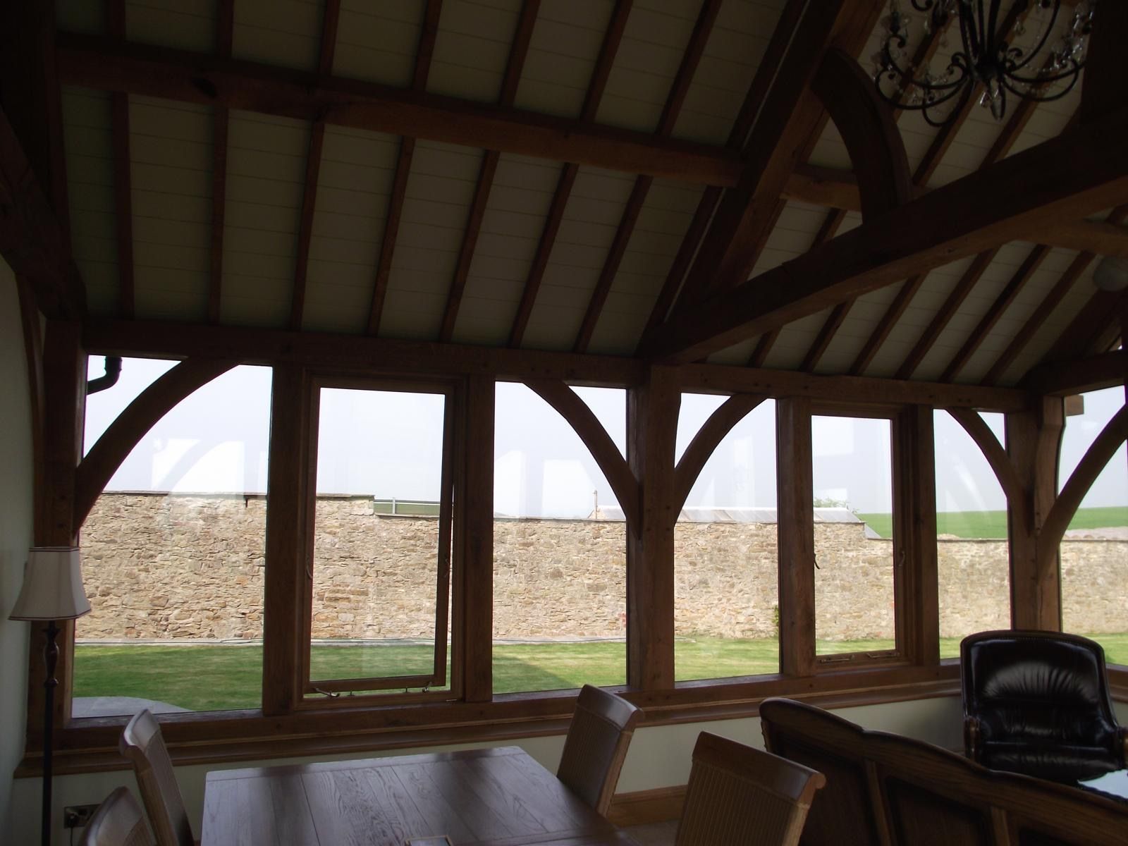 A room with a table and chairs and lots of windows