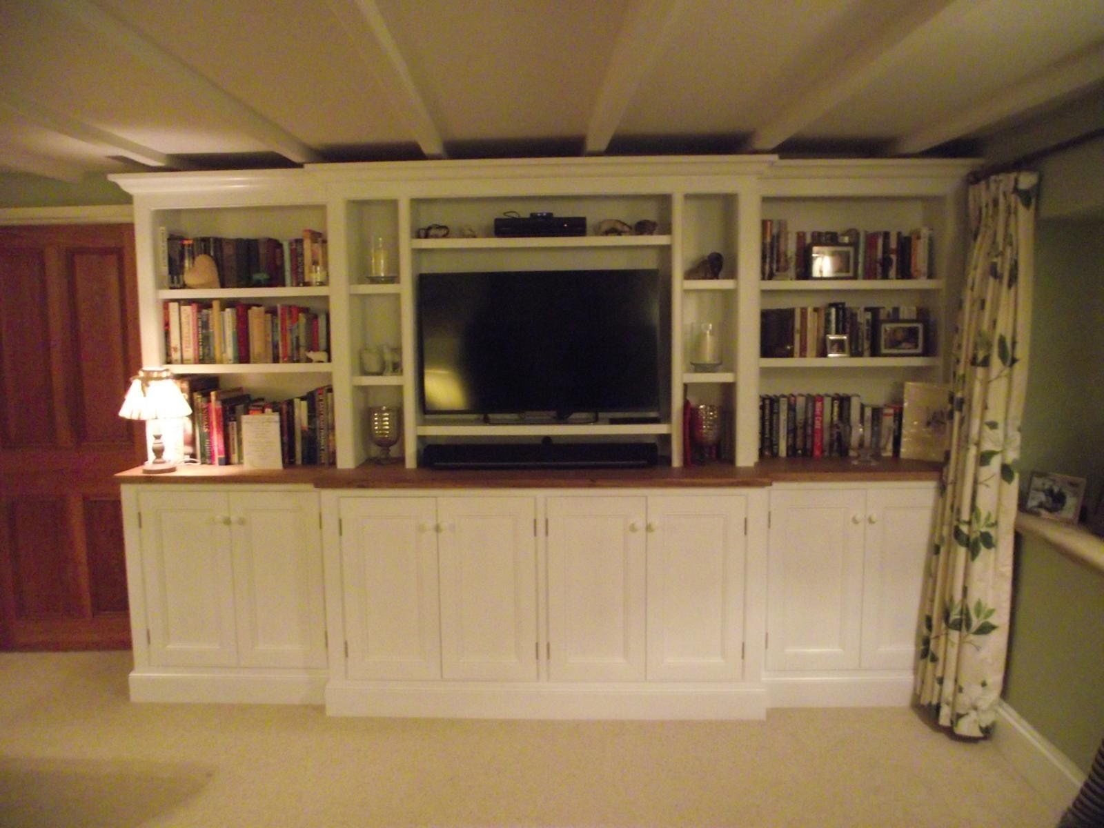 A large entertainment center with a flat screen tv and bookshelves