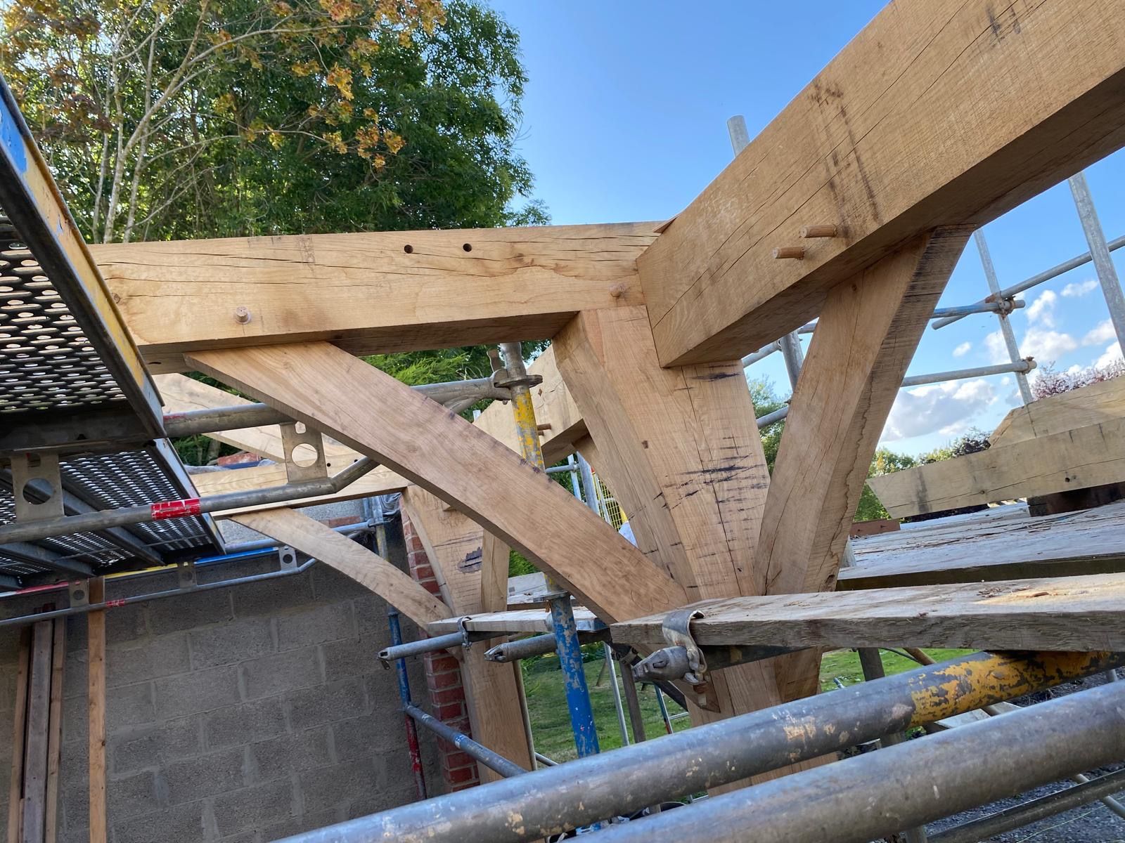 A wooden structure is being built on top of a brick building.