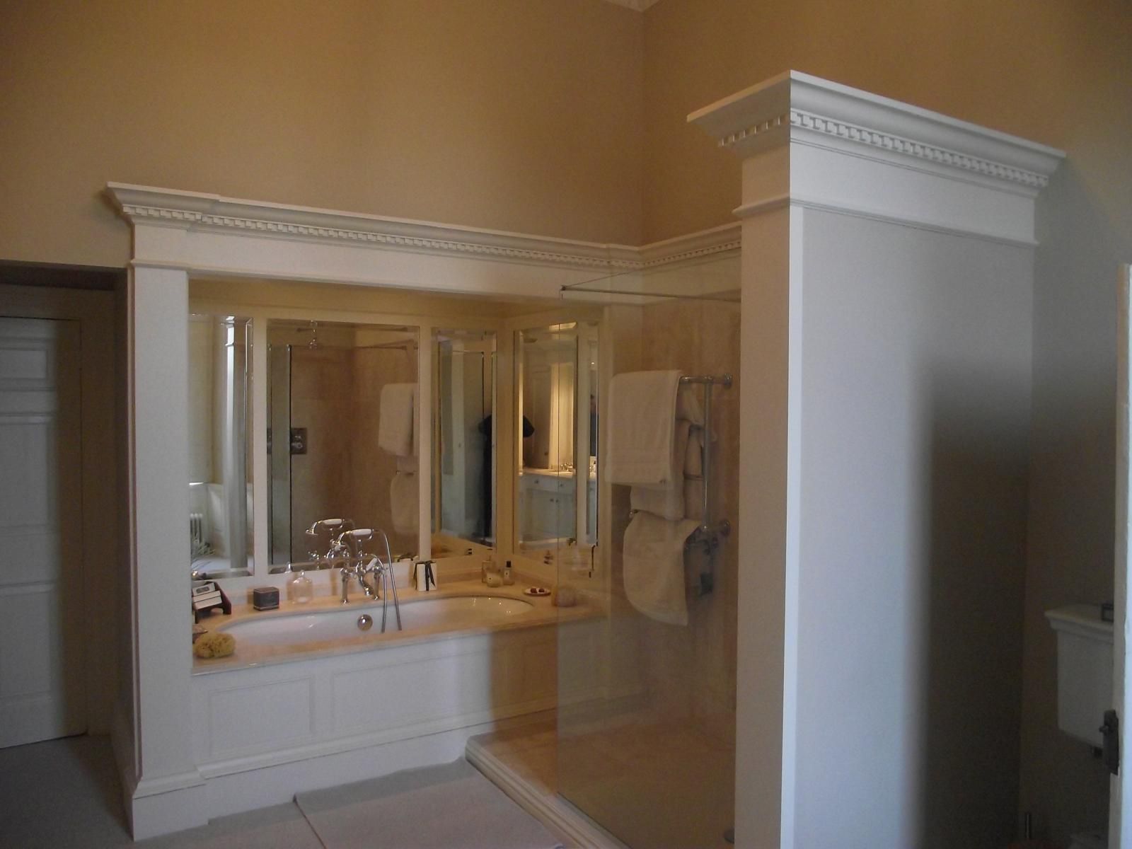 A bathroom with two sinks , a tub , and a walk in shower.