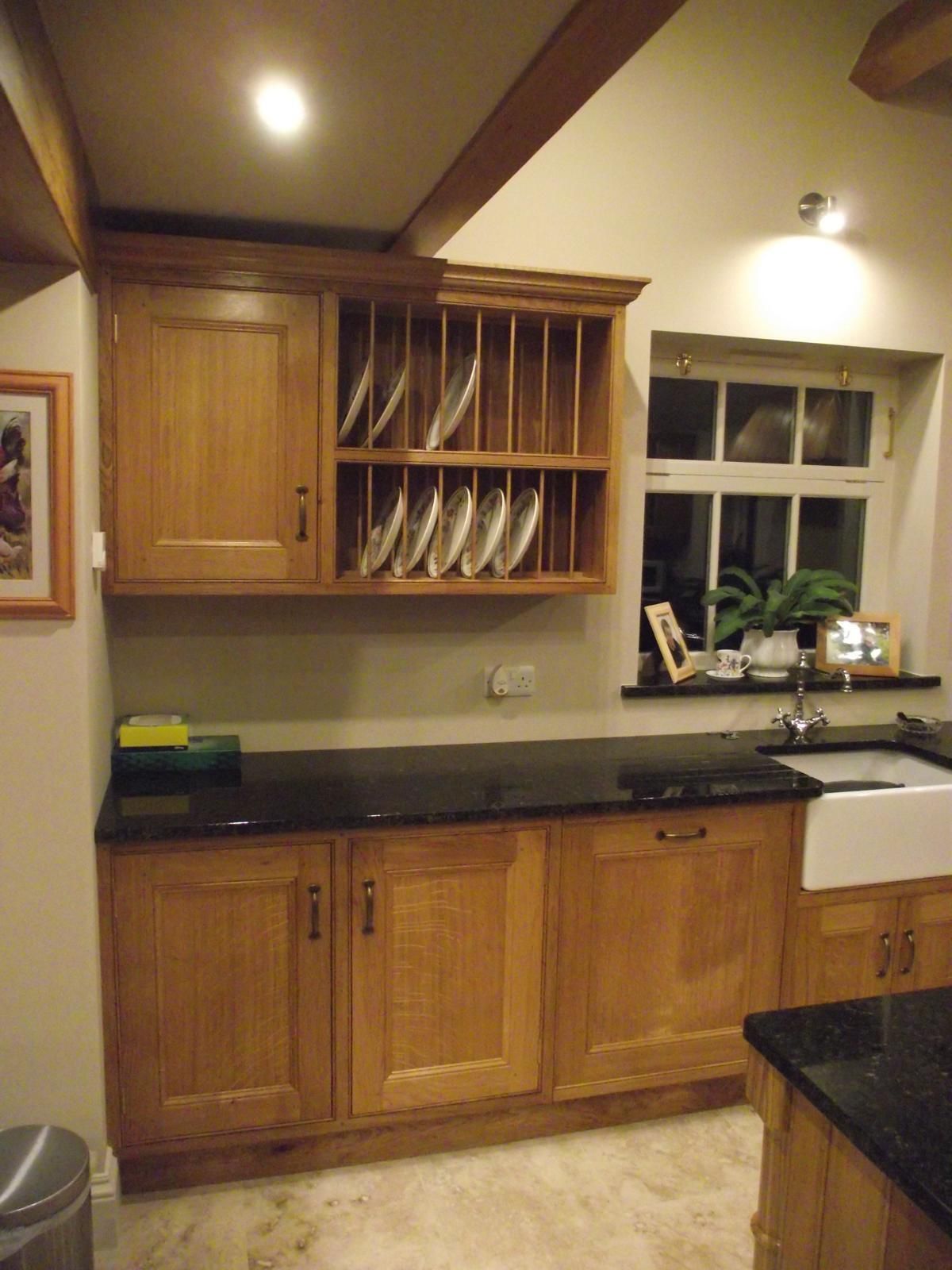 A kitchen with wooden cabinets and a black counter top