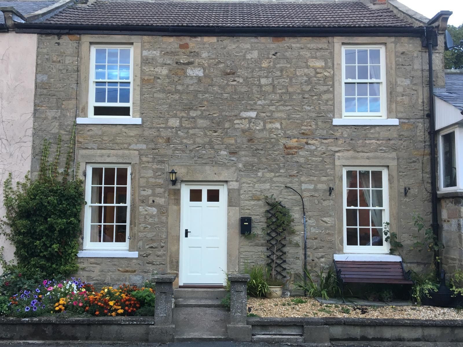 A brick house with white windows and a white door