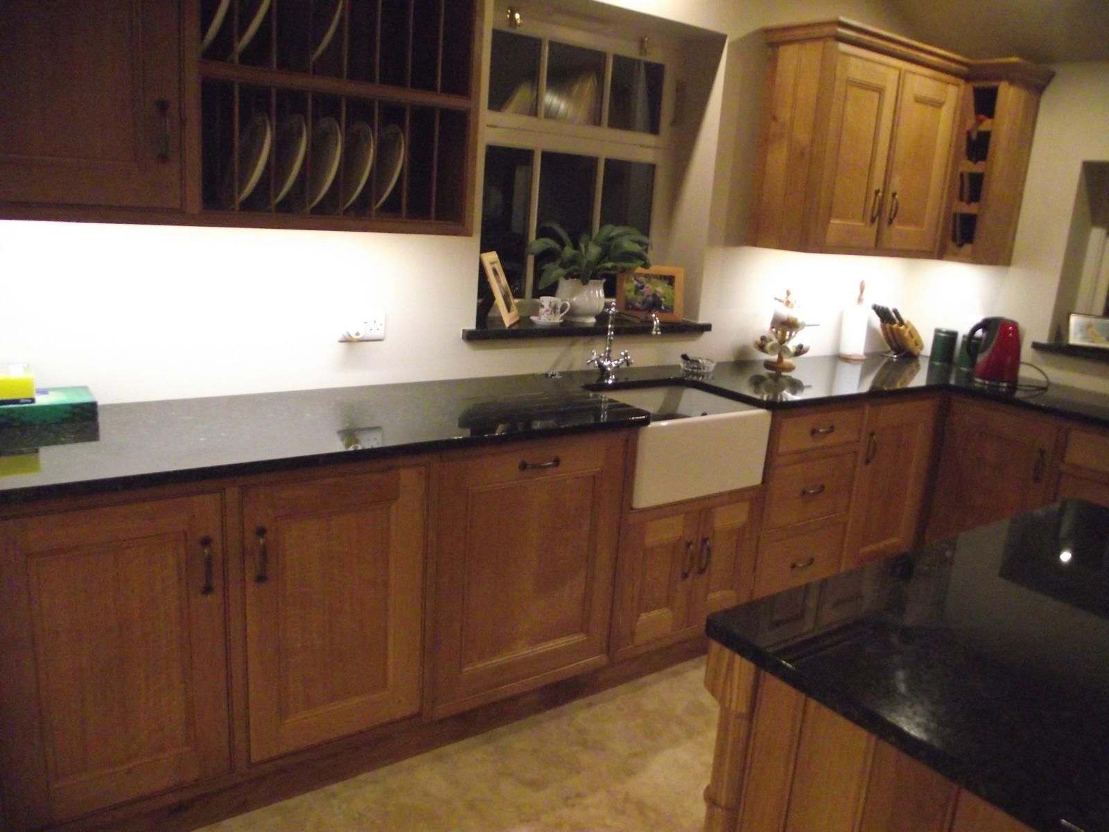 A kitchen with wooden cabinets and black counter tops