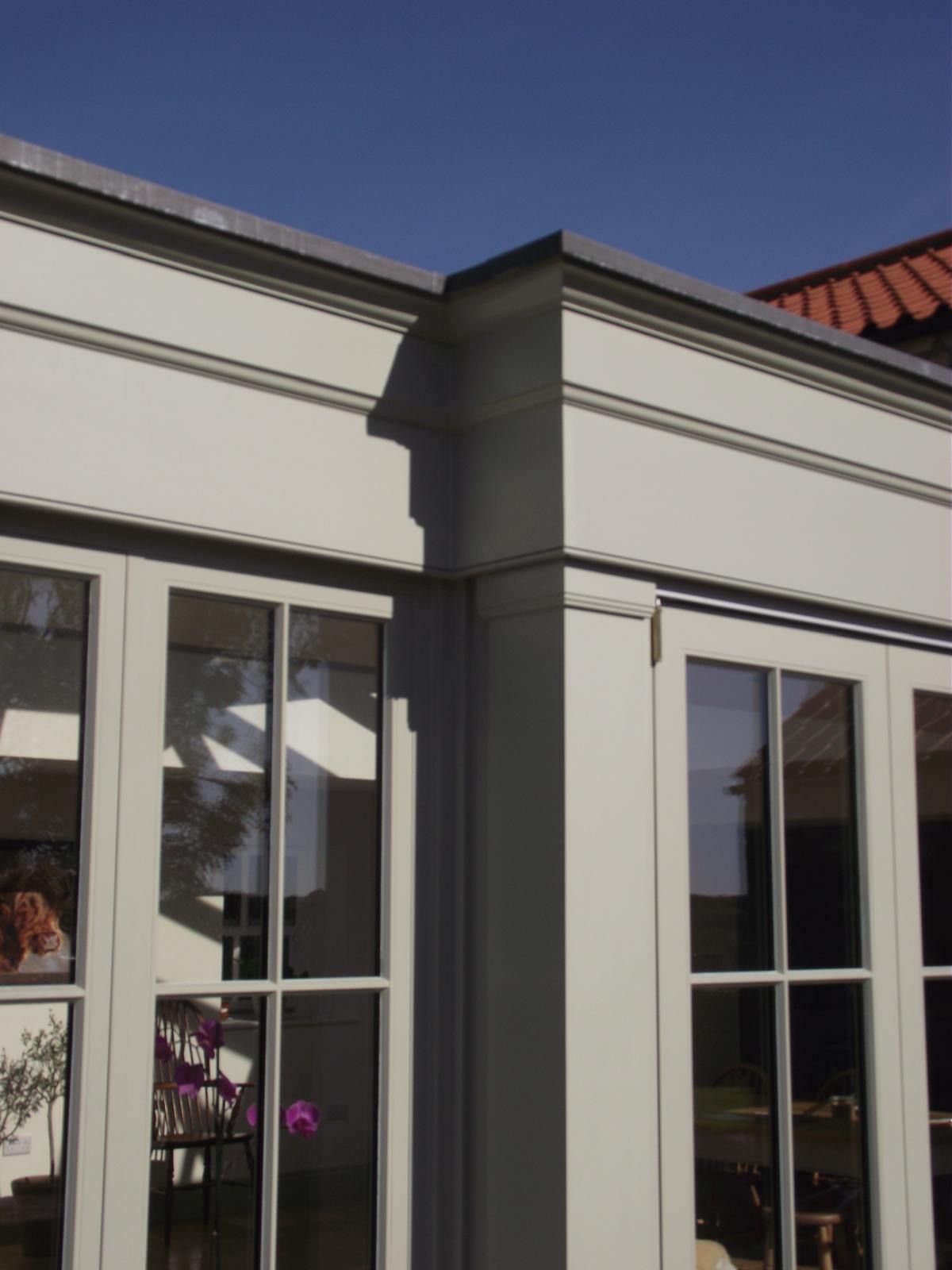 A white building with a lot of windows and a blue sky in the background