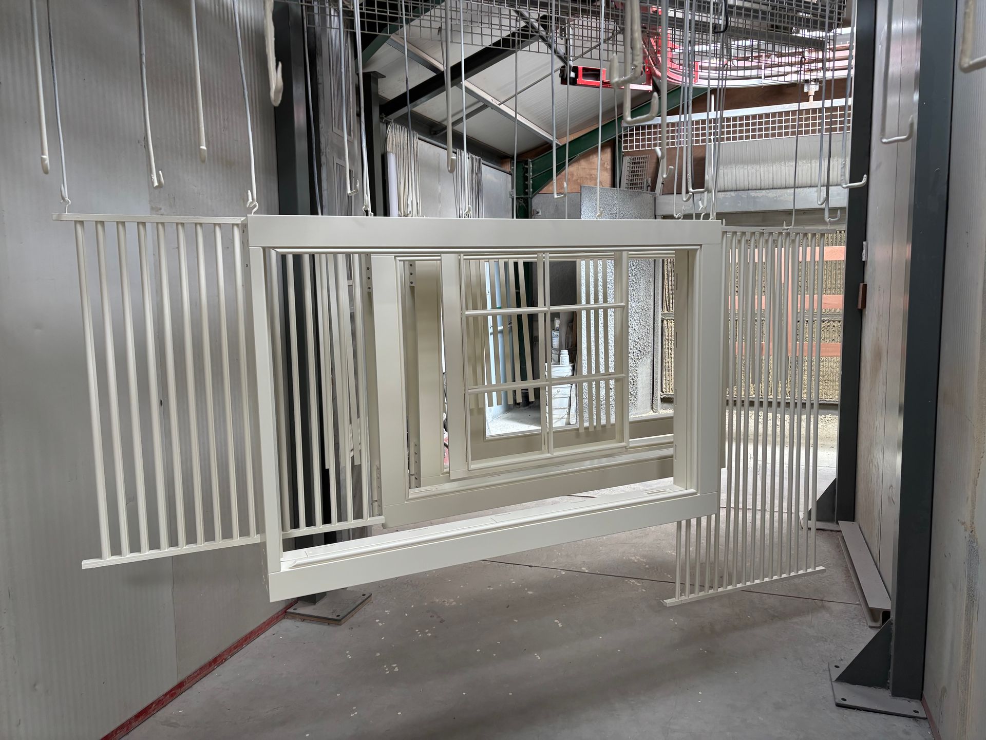 A white railing is hanging from the ceiling in a room.