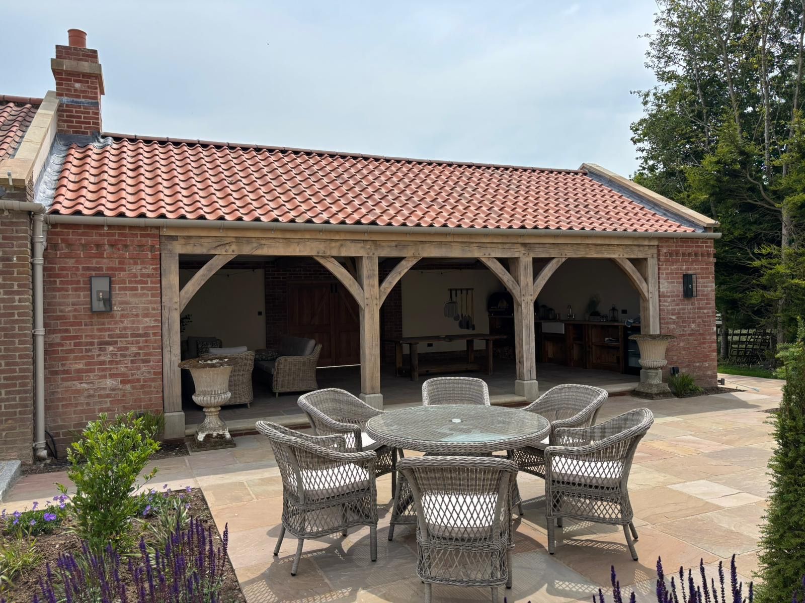 A patio with a table and chairs in front of a brick building.