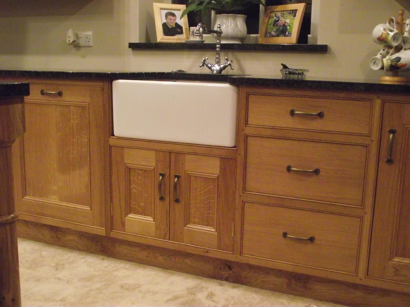 A kitchen with wooden cabinets and a white sink