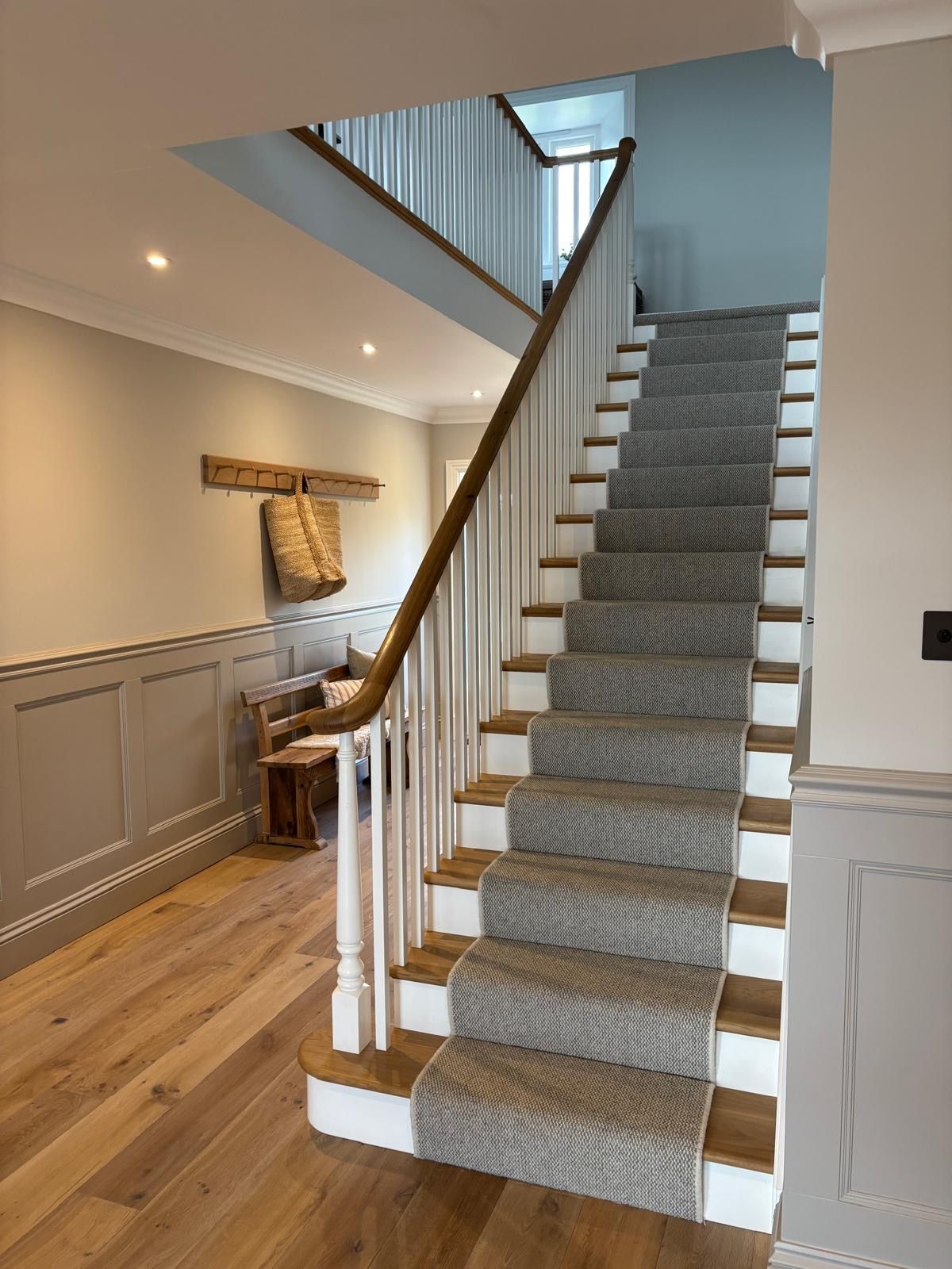 A staircase with a carpet on the steps and a wooden railing.