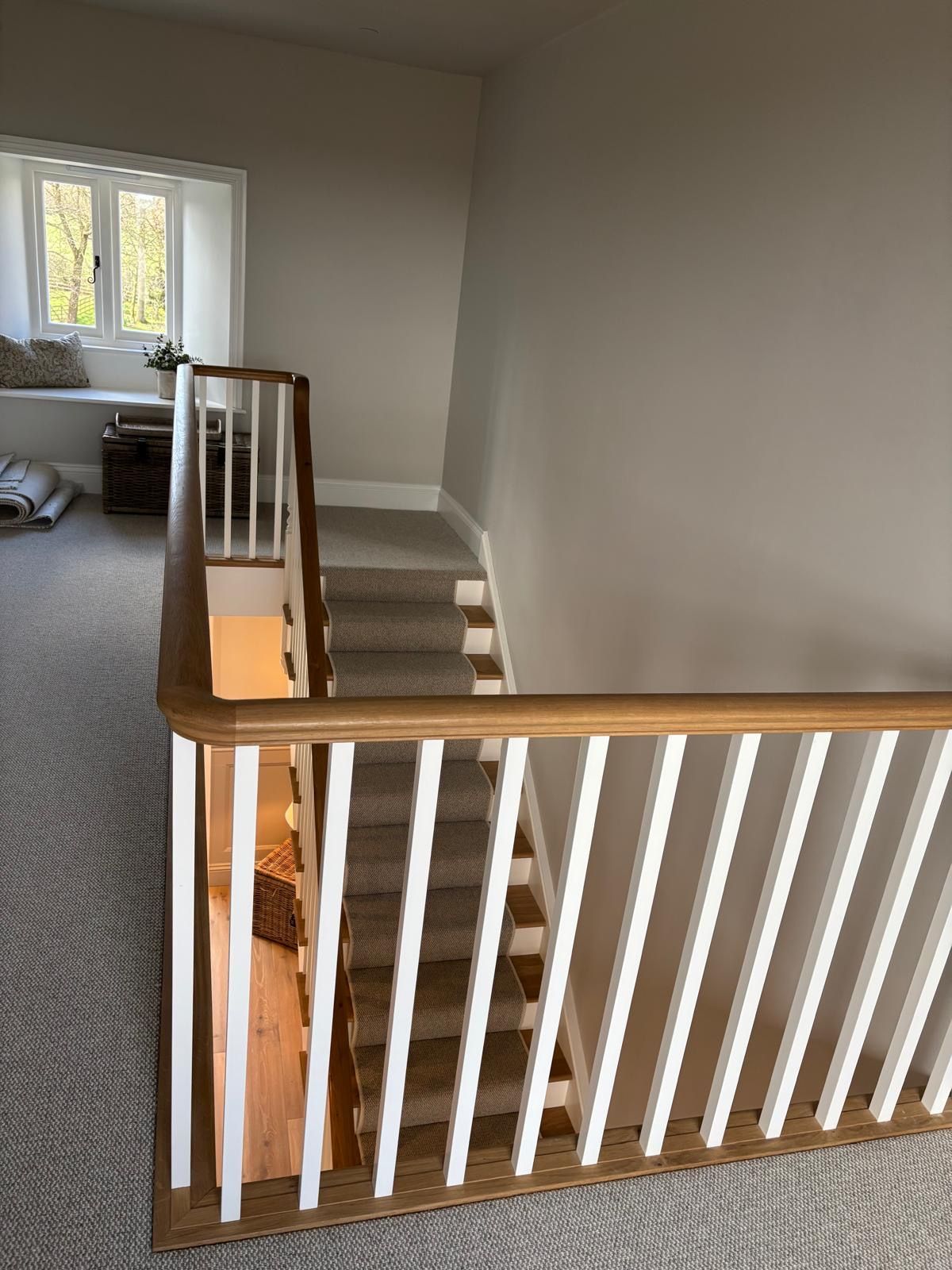 A staircase with a wooden railing leading up to the second floor of a house.
