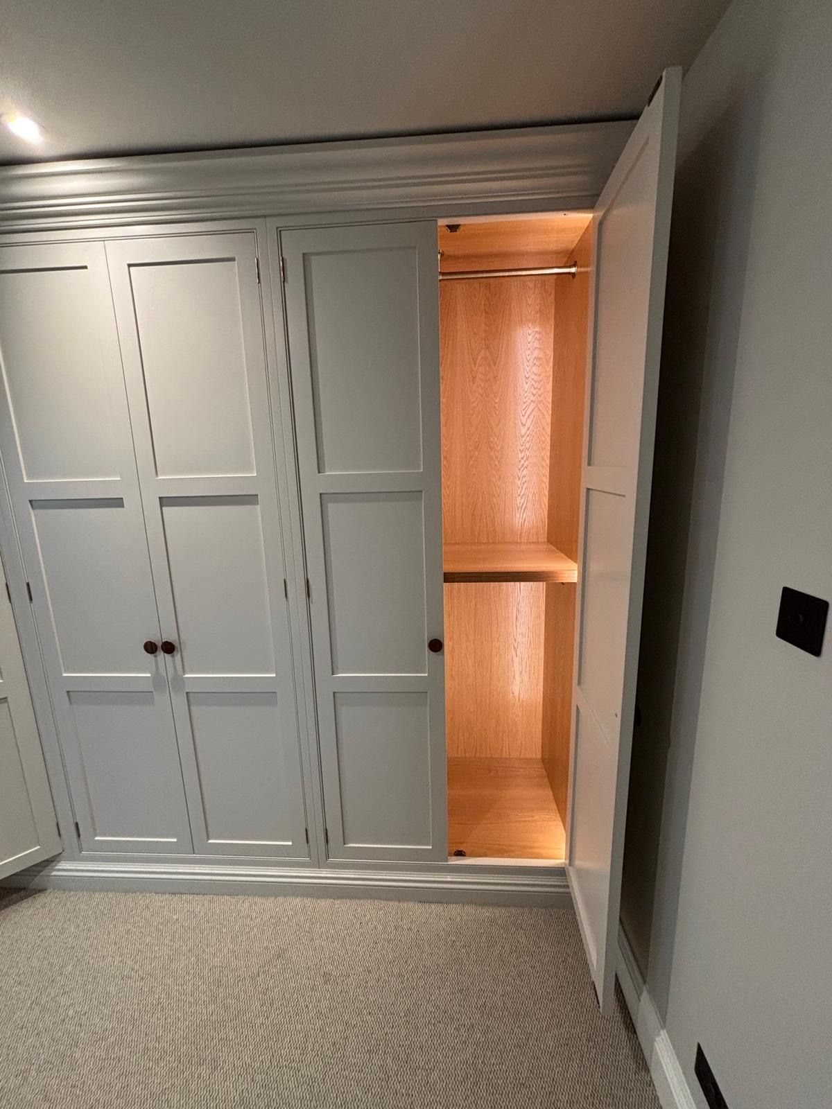 A wardrobe with the door open in a room.