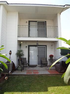 A white house with a balcony and sliding glass doors