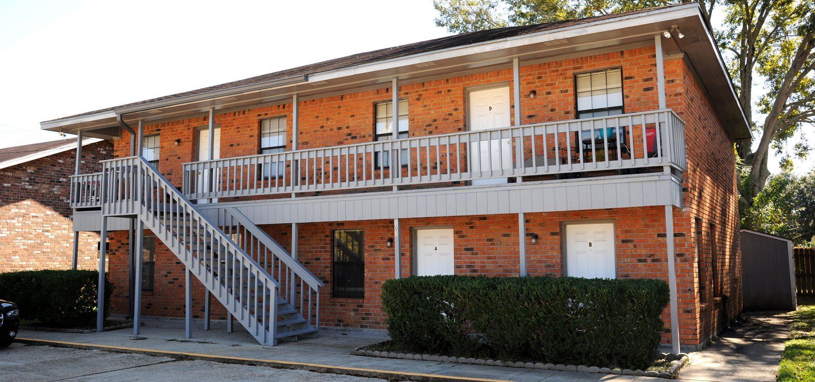 A brick apartment building with stairs leading up to the second floor
