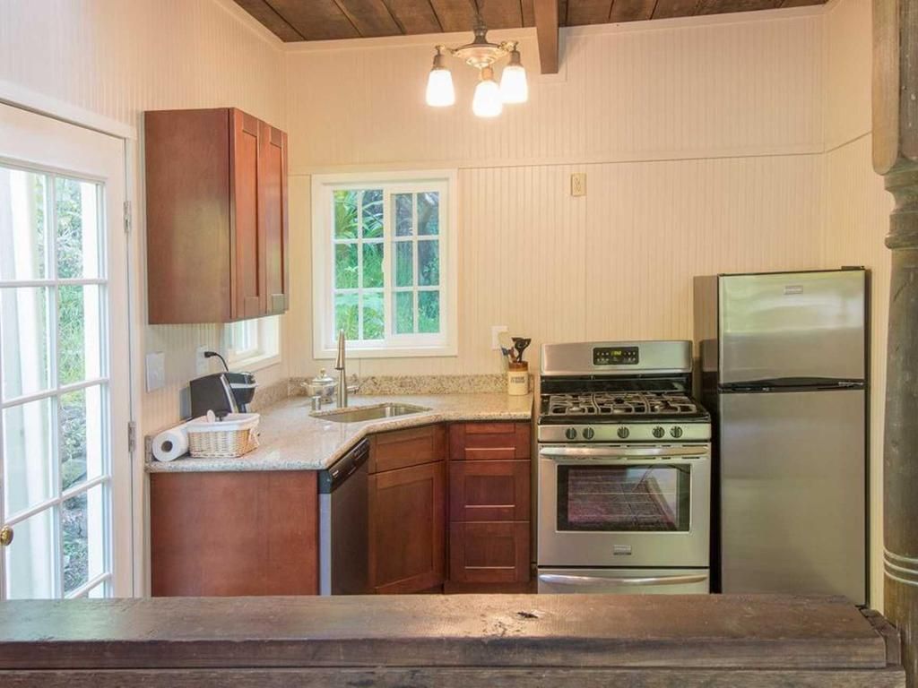 Small kitchen with wooden cabinets, stainless steel appliances, and a window.