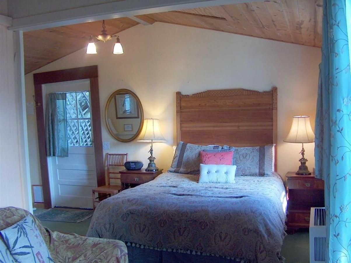 Bedroom with a bed, nightstands, and a door, seen from a doorway.