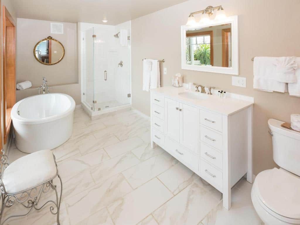 Spacious bathroom with white fixtures, a glass shower, and a soaking tub.