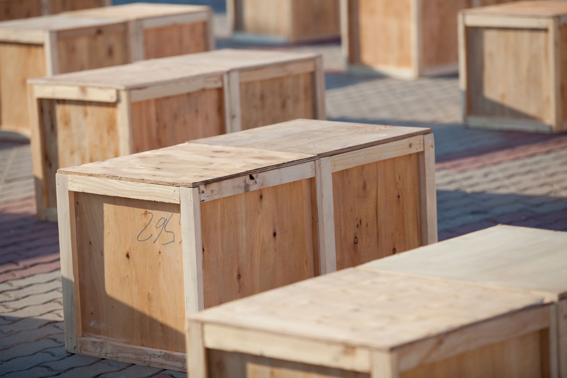 A row of wooden boxes sitting on top of a brick sidewalk.