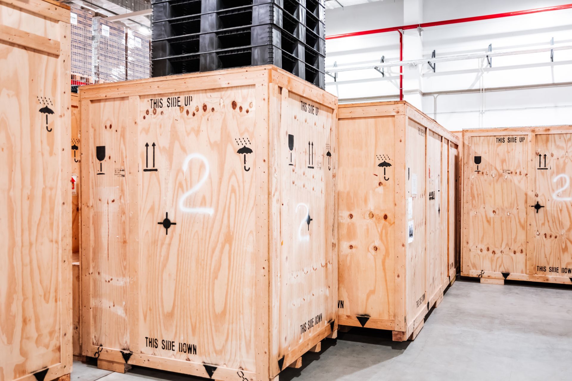 A row of wooden crates are lined up in a warehouse.
