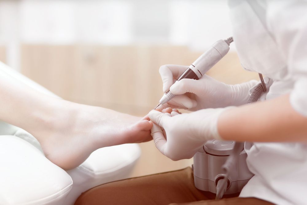 A Woman is Getting Her Nails Done by a Nail Technician — Newcastle Foot & Ankle Clinic Charlestown In Charlestown, NSW