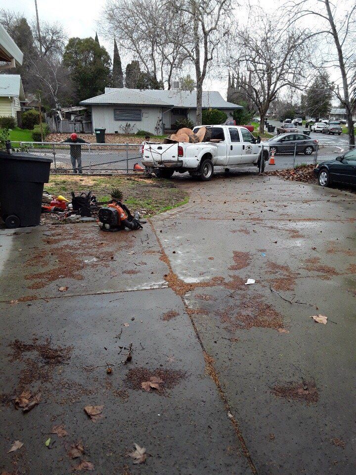 A white truck is parked on the side of the road in front of a house.