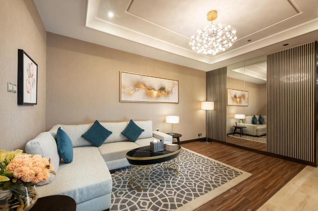 Living room with a gray sectional sofa, rug, and coffee table; modern design.
