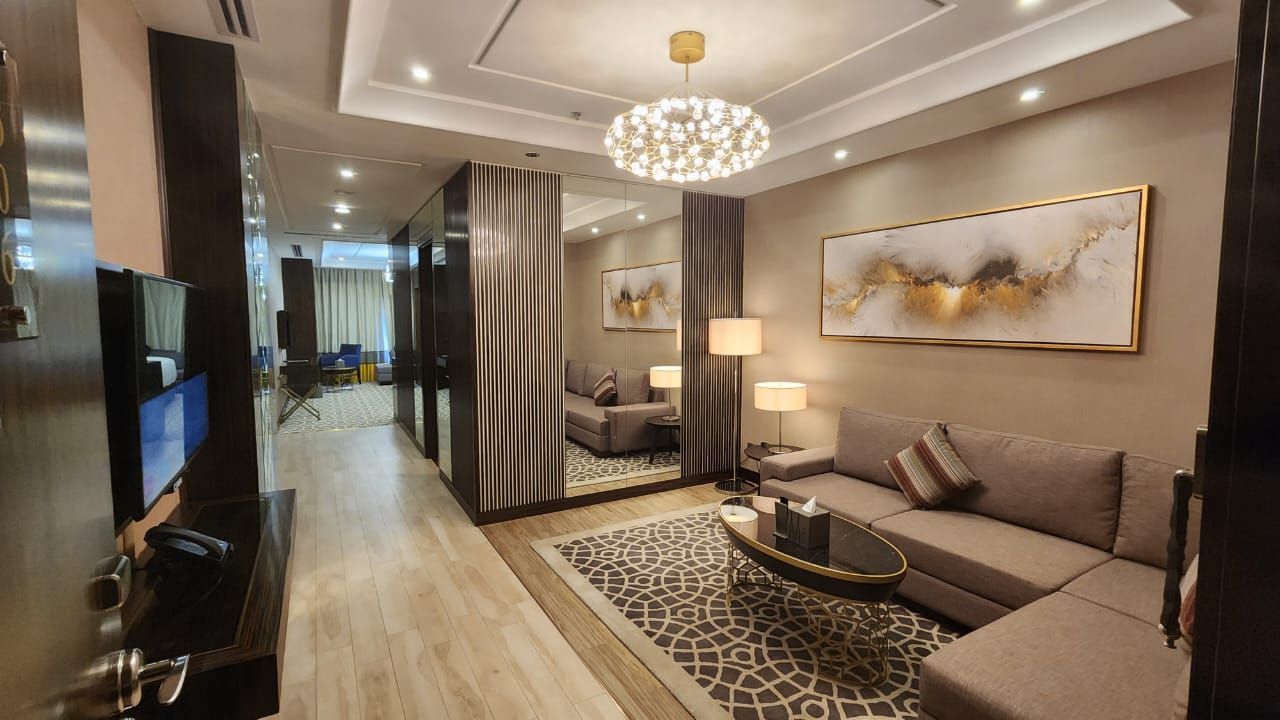 Luxurious living room with sectional sofa, rug, and gold abstract art.