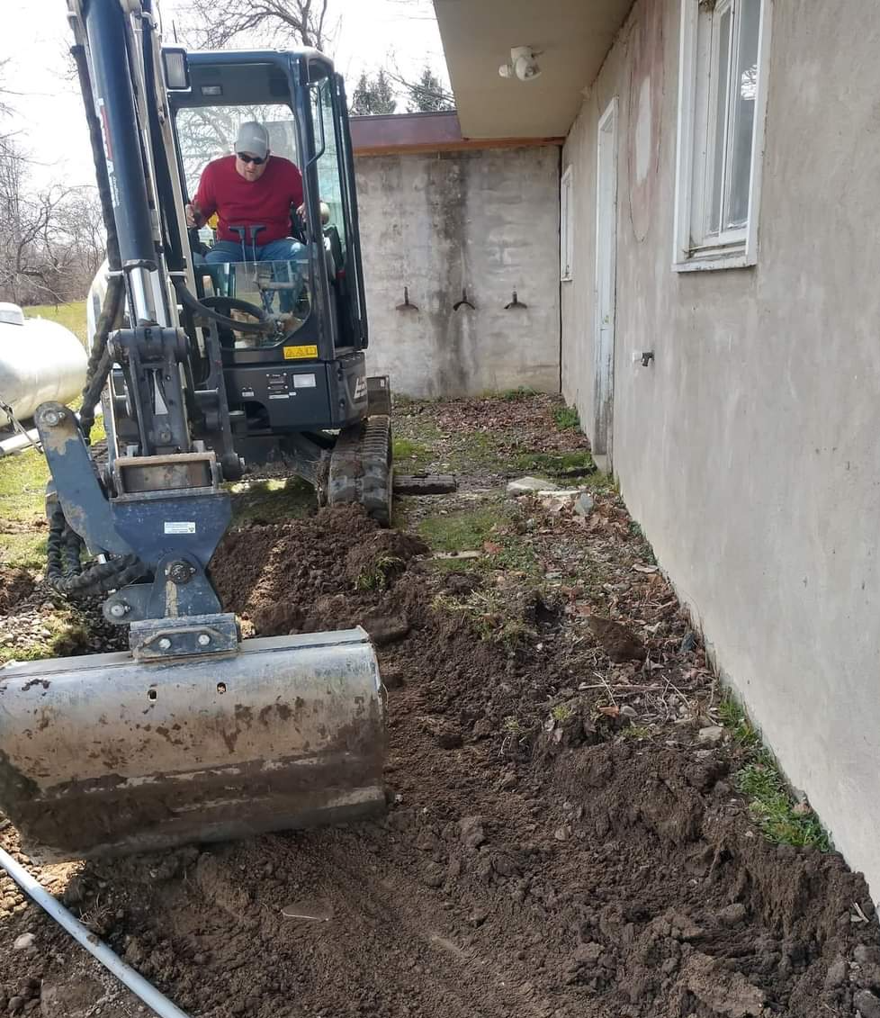 a man is driving an excavator in front of a house
