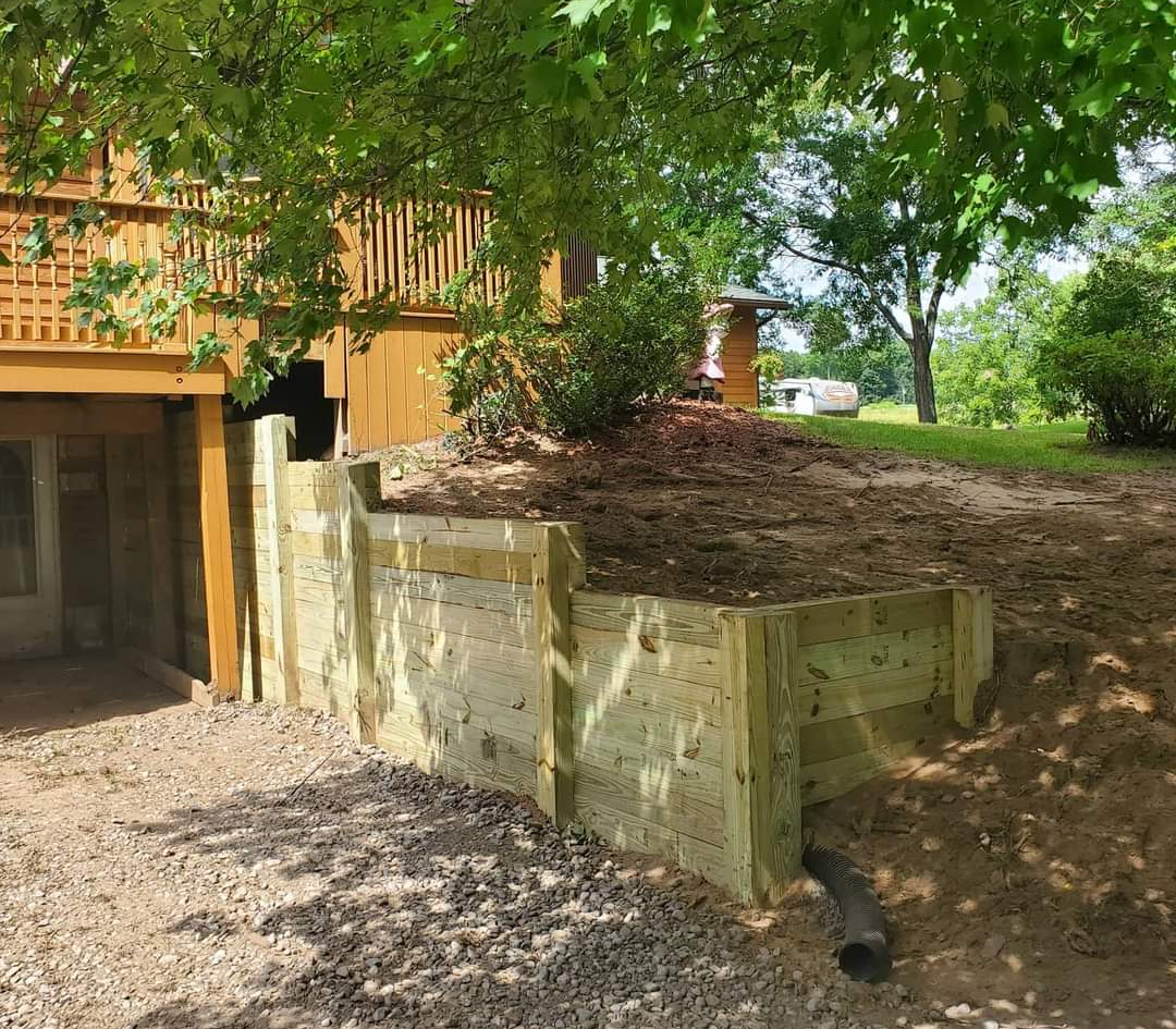 a wooden retaining wall is being built in front of a house