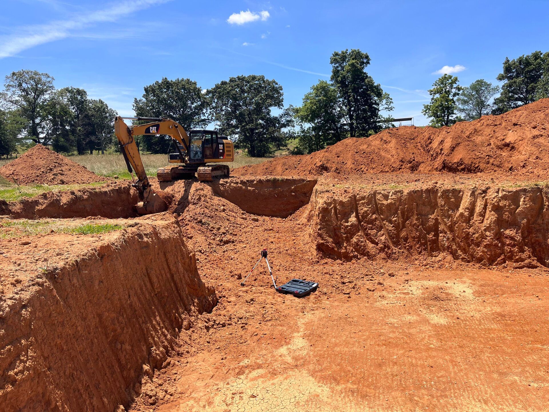 a cat excavator is digging a hole in the dirt