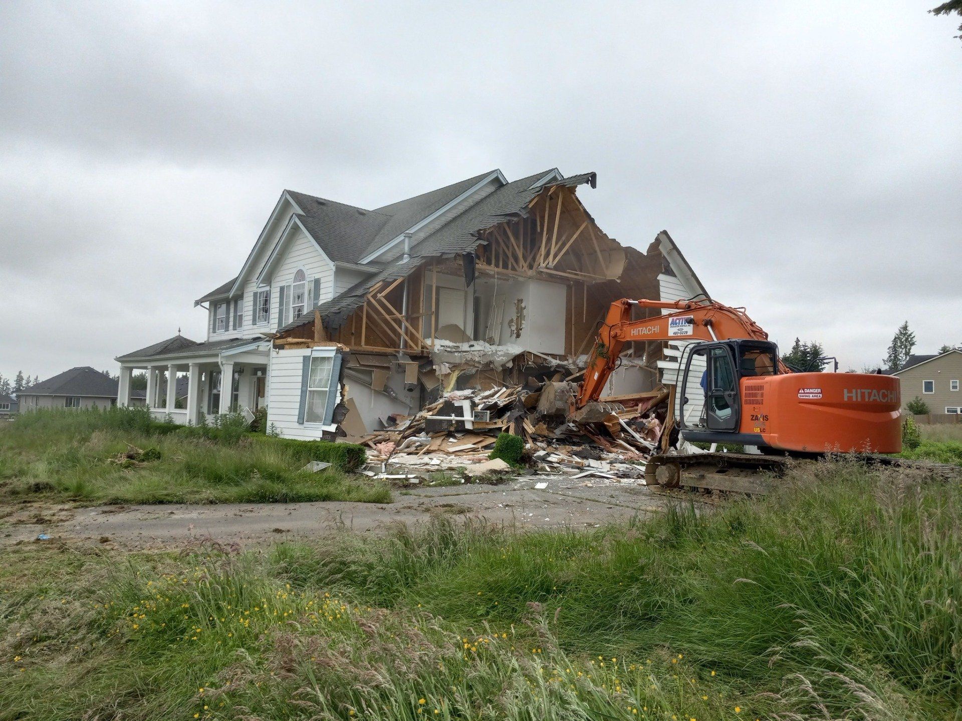a large house is being demolished by a hitachi excavator