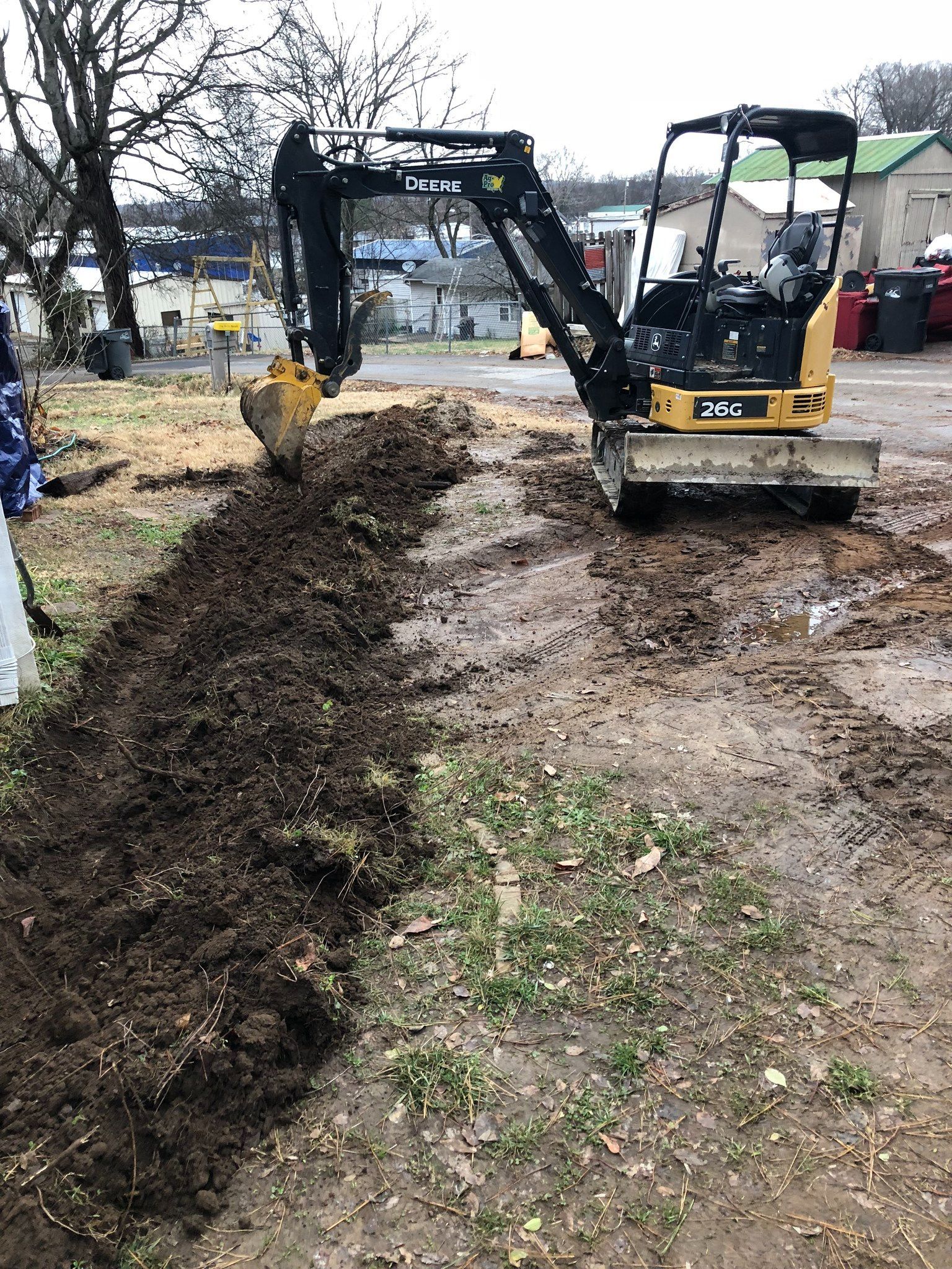 A small excavator is digging a hole in the ground.