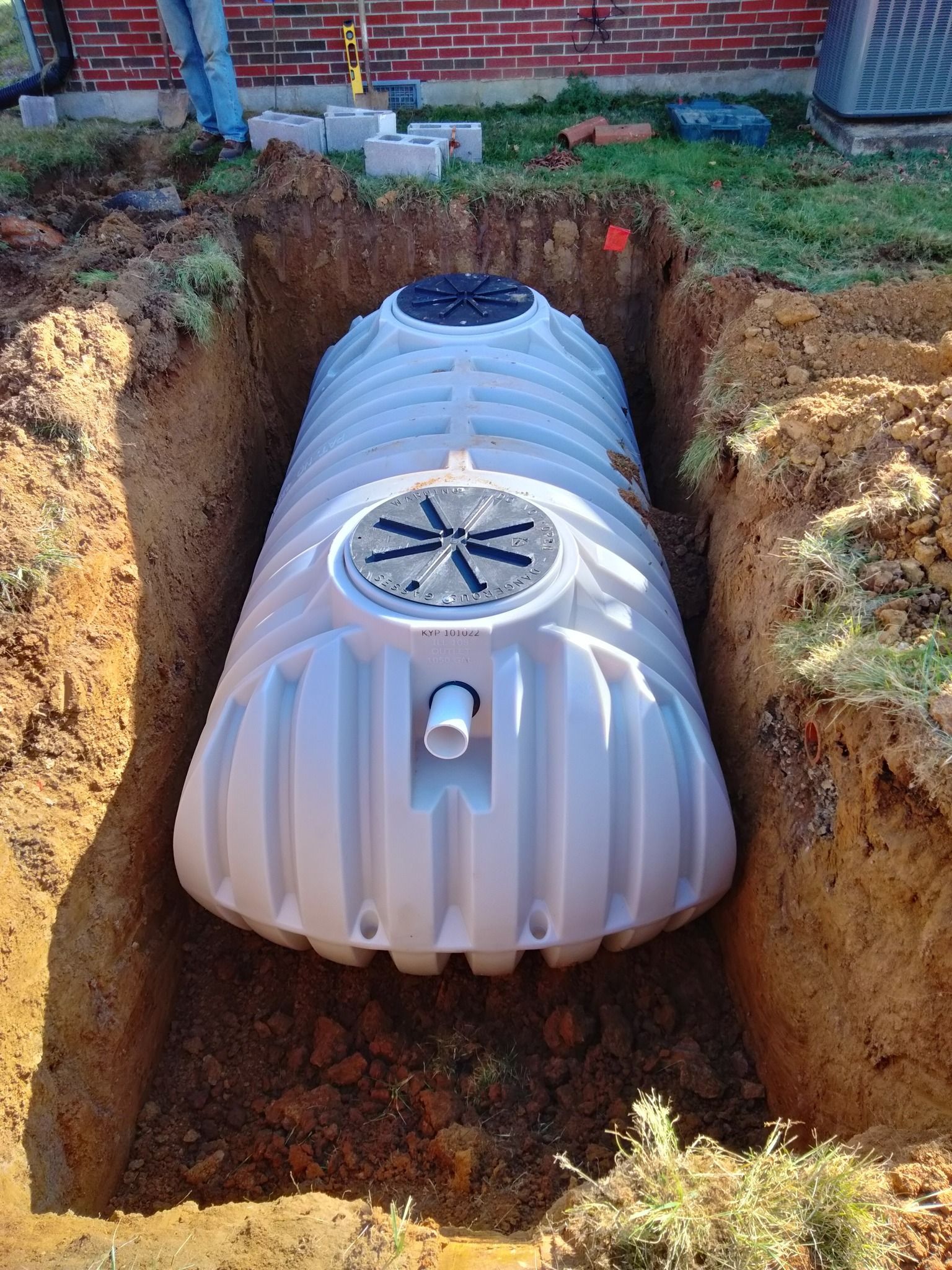 A large white tank is sitting in a hole in the ground.