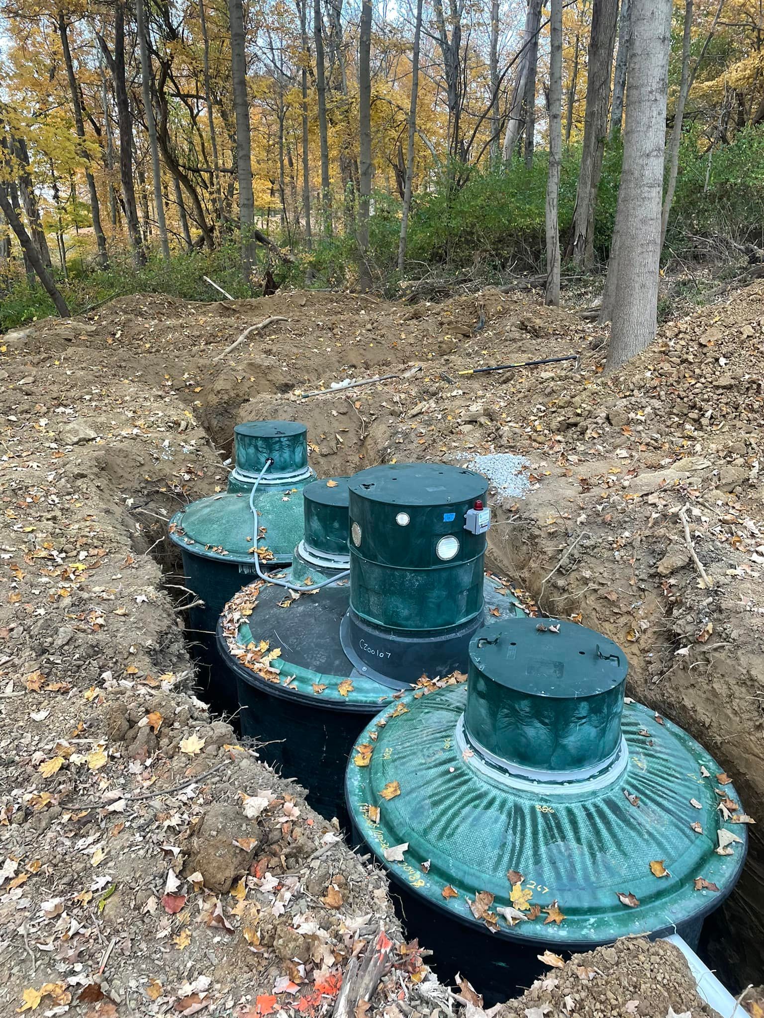 A group of septic tanks are sitting in the middle of a forest.