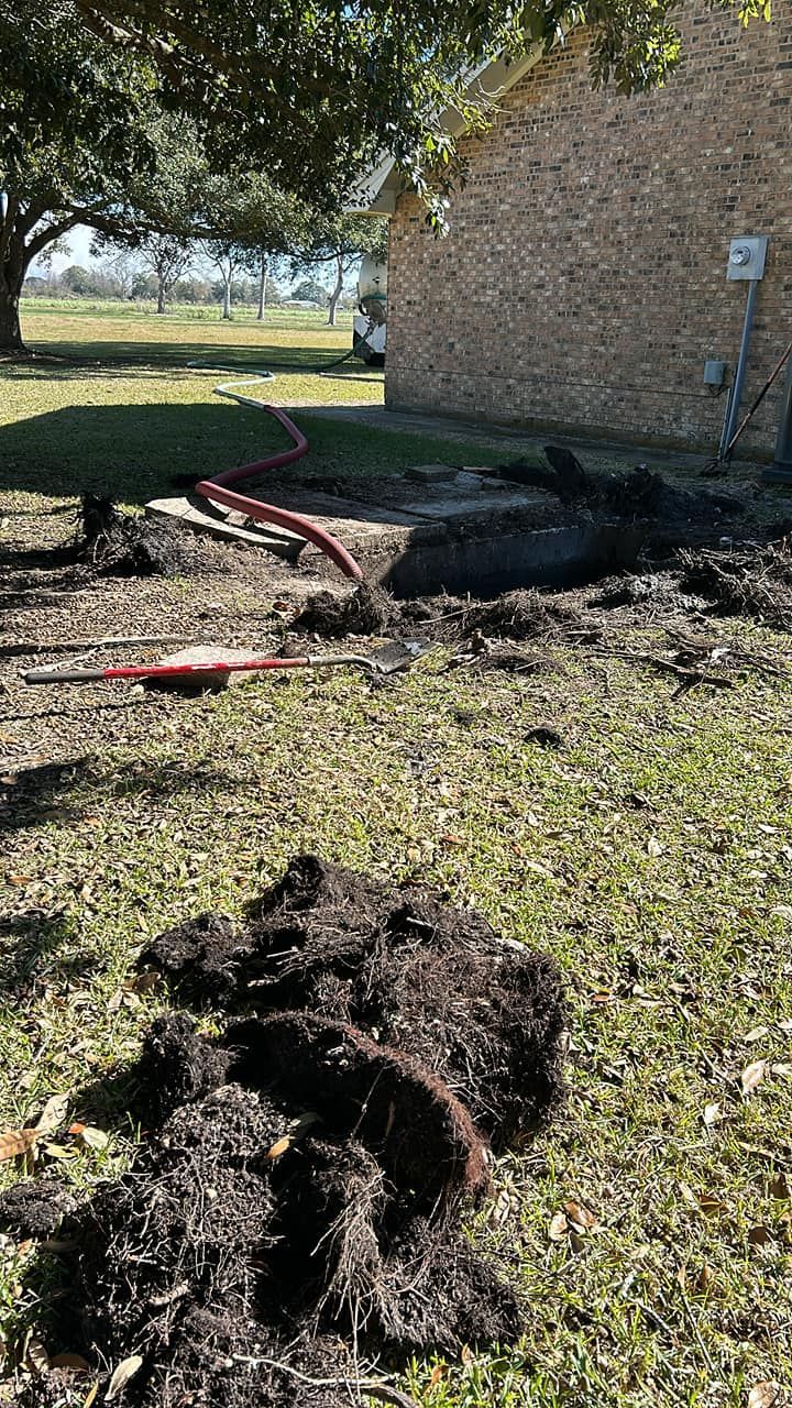 A pile of dirt is sitting in the grass in front of a house.