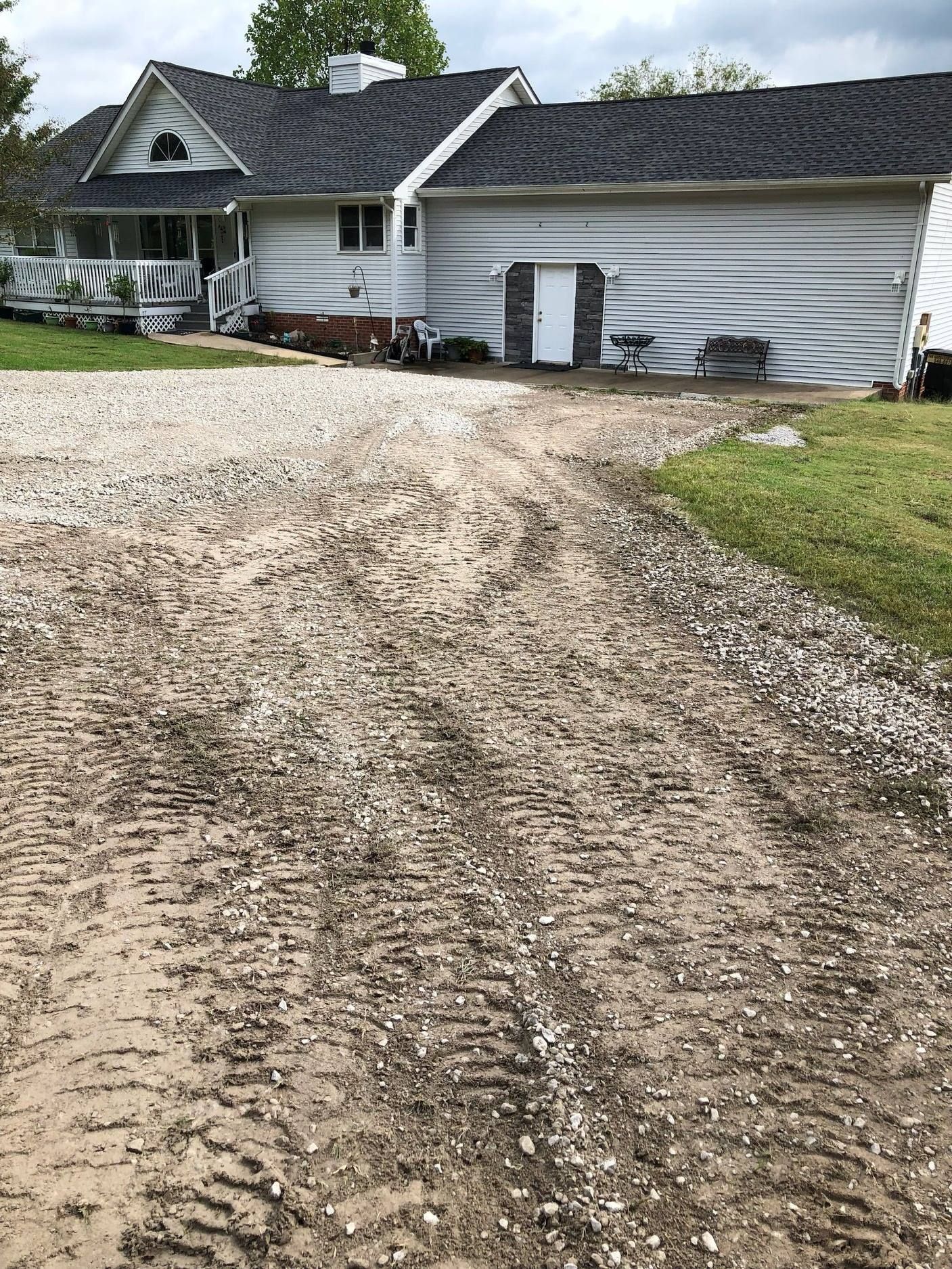 There is a dirt road leading to a house.