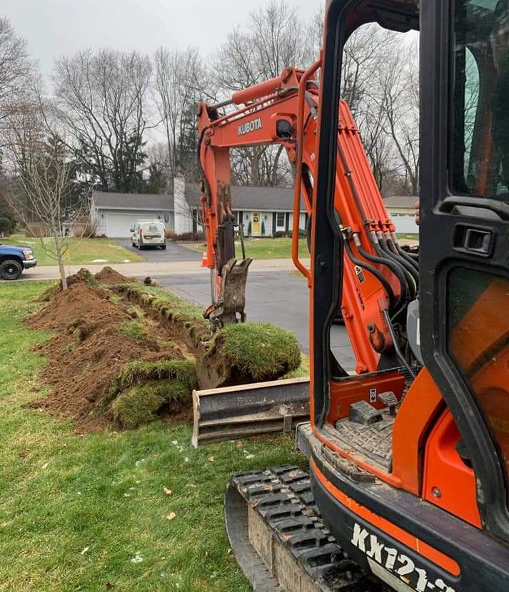 a kubota excavator is digging a hole in a yard