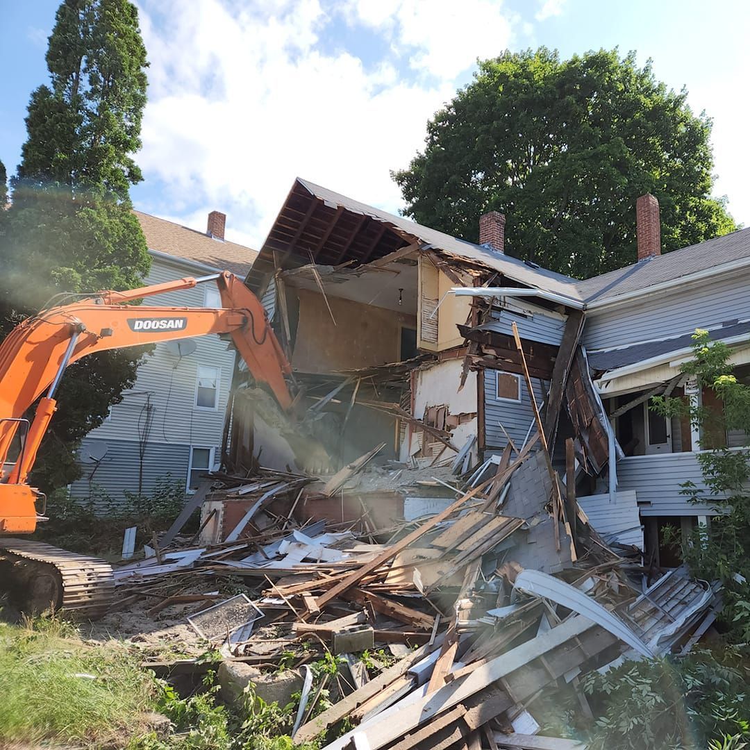 an orange doosan excavator is demolishing a house
