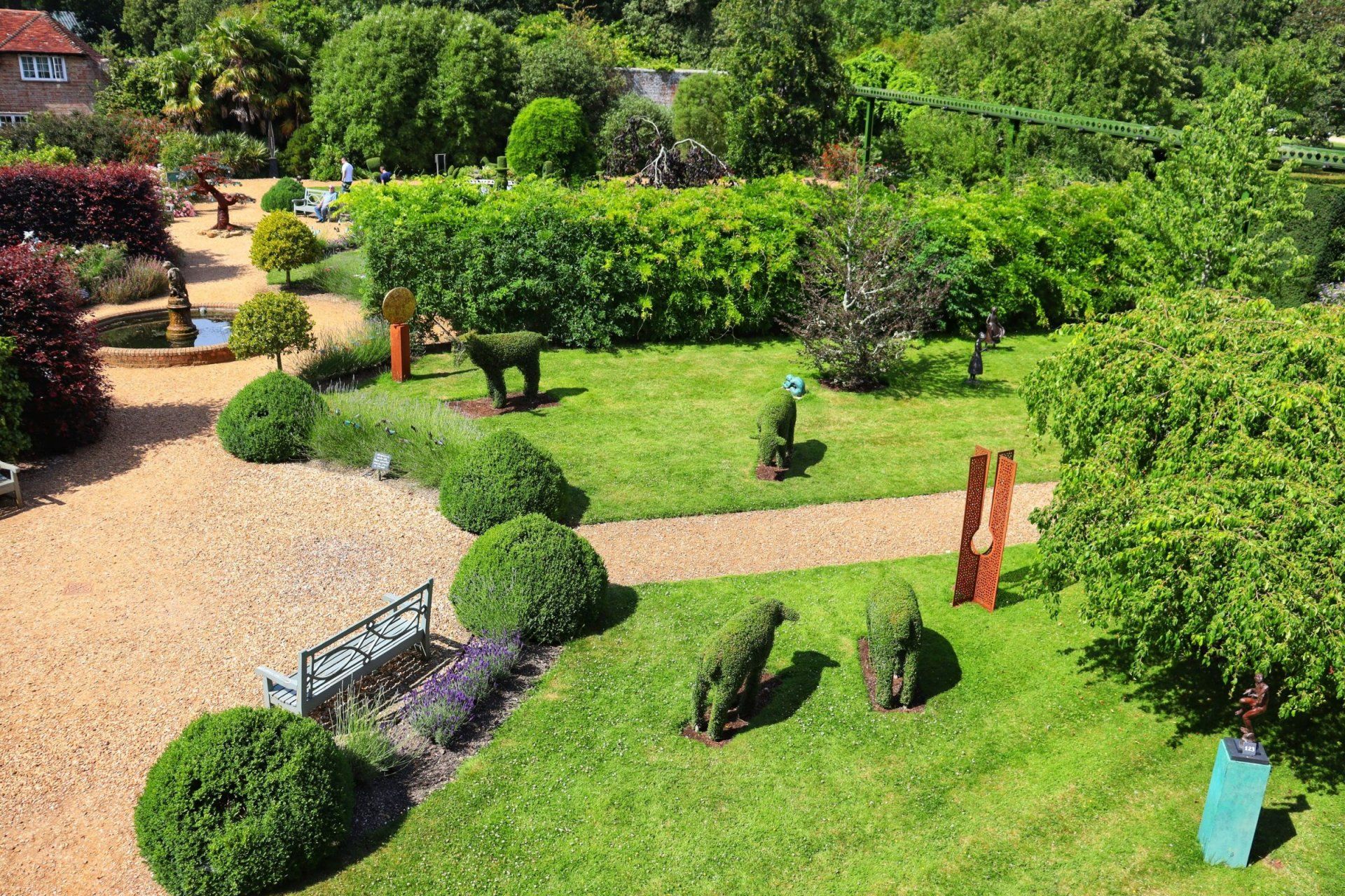 an aerial view of a garden with a bench and sculptures