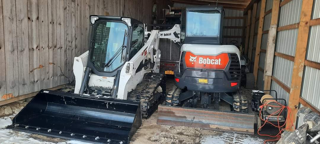 two bobcat tractors are parked in a garage