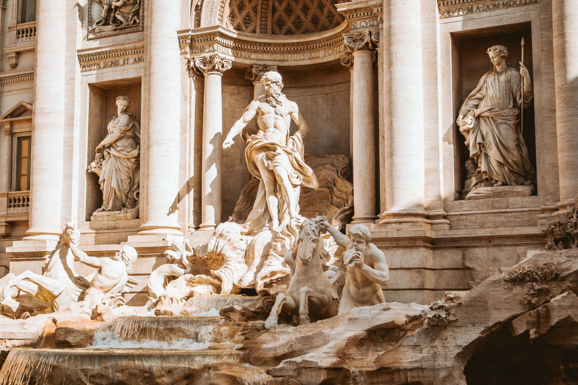 a fountain with a statue of a man standing next to a horse and a statue of a woman
